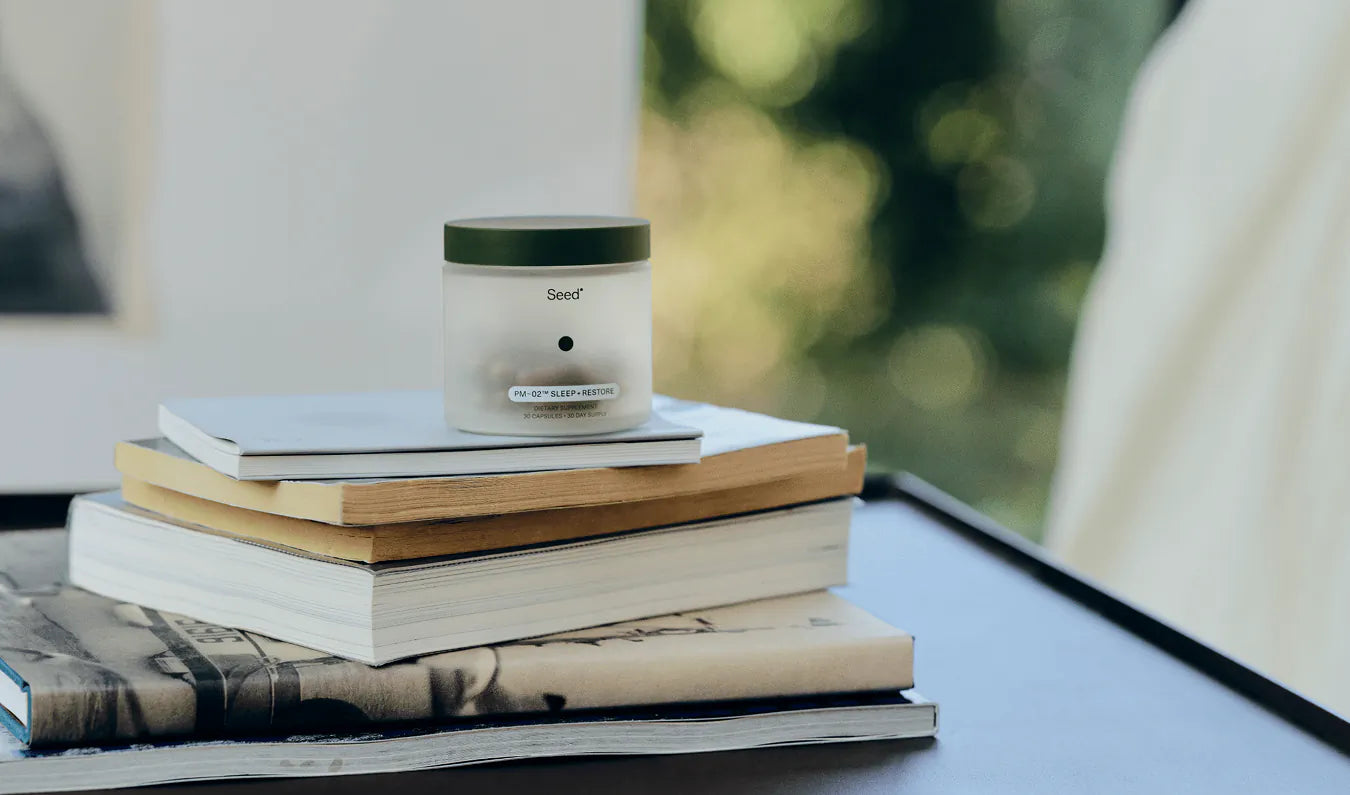 Jar of 'Seed' skincare product with packaging and a glass container on a light gray background